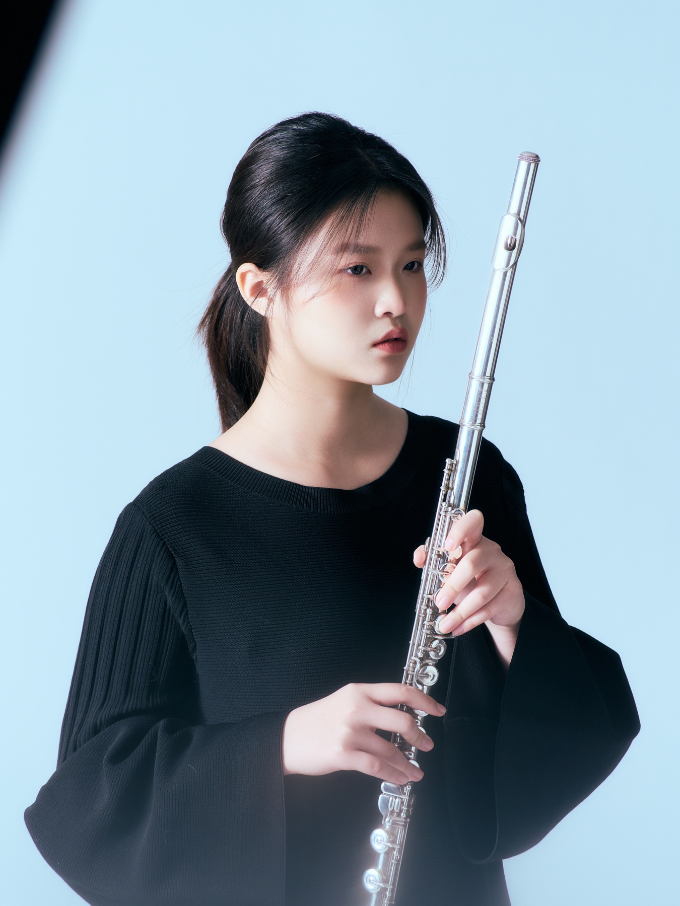 Schuwen Zheng holding a flute upright